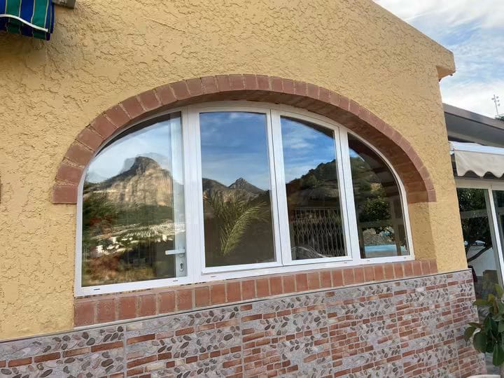 Ventana blanca adaptada a un hueco arqueado